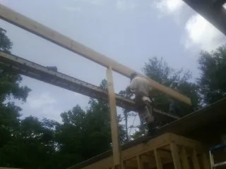 Carpenter setting a ridge beam over a new addition frame — Ice Dam Removal by Roofing Brothers in Fleetville