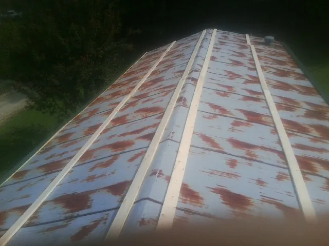 Rusted metal roof panels with new wood purlins before replacement — Storm Damage Roof Repair in Fleetville by Roofing Brothers