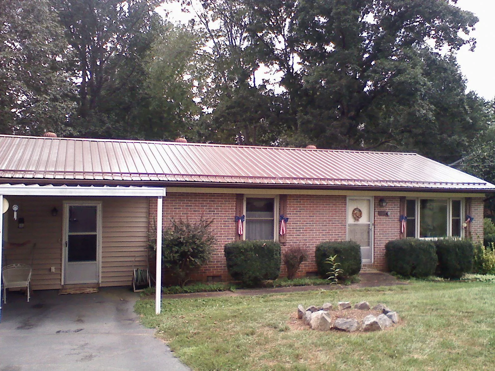 Bronze metal roof and carport on a brick ranch home — Roof Repair work by our crew in Fleetville
